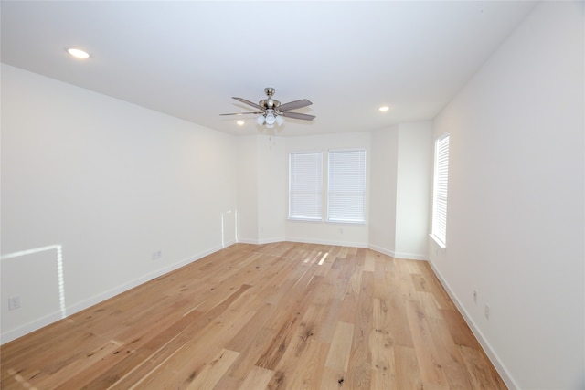 spare room with ceiling fan and light wood-type flooring