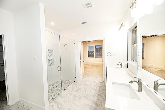 bathroom featuring a shower with door and vanity