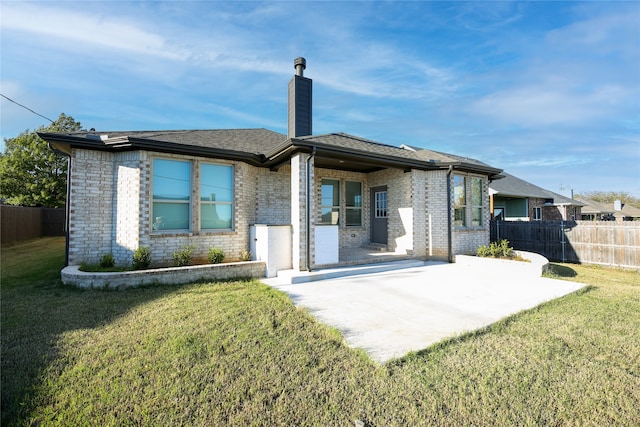 rear view of house with a patio and a lawn