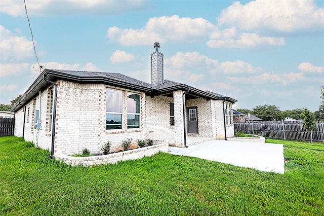 back of property with a yard and a patio