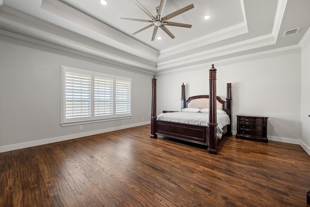 bedroom featuring dark wood-style flooring, crown molding, a raised ceiling, visible vents, and baseboards