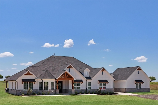 view of front of house featuring board and batten siding, a front yard, and roof with shingles