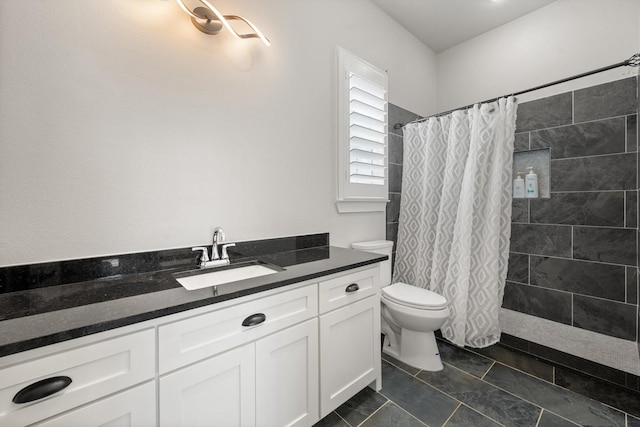 full bathroom with toilet, tiled shower, and vanity