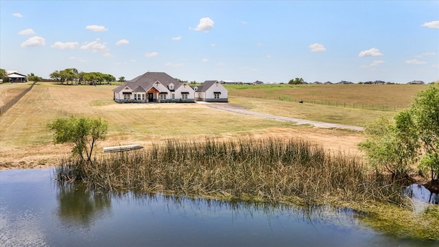 rear view of house featuring a rural view and a water view