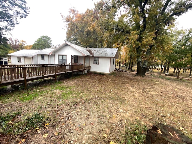 rear view of house featuring a wooden deck