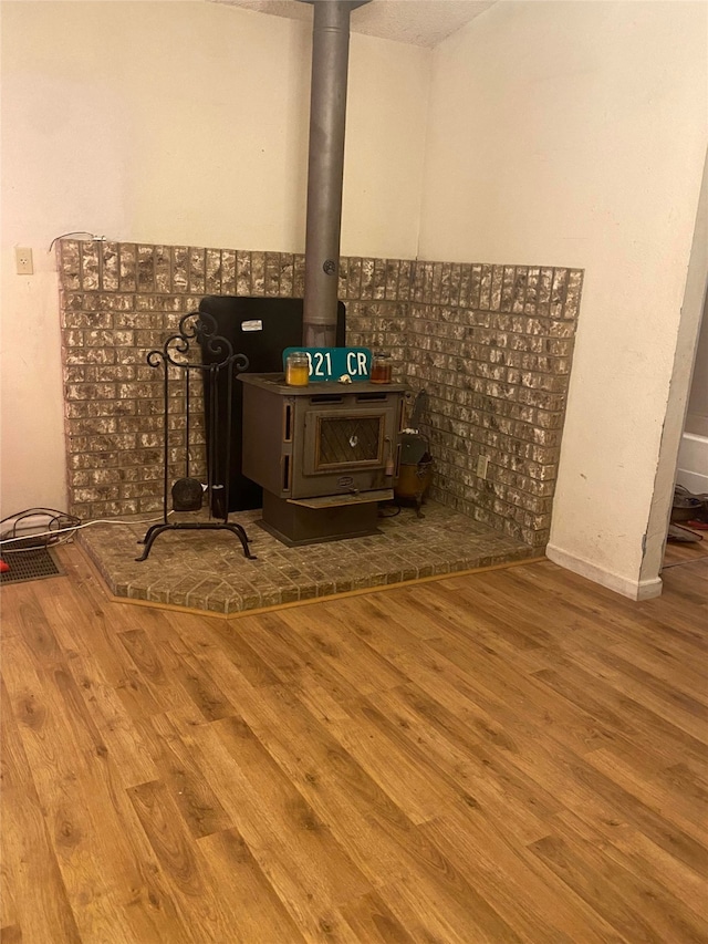 details featuring a wood stove and hardwood / wood-style floors