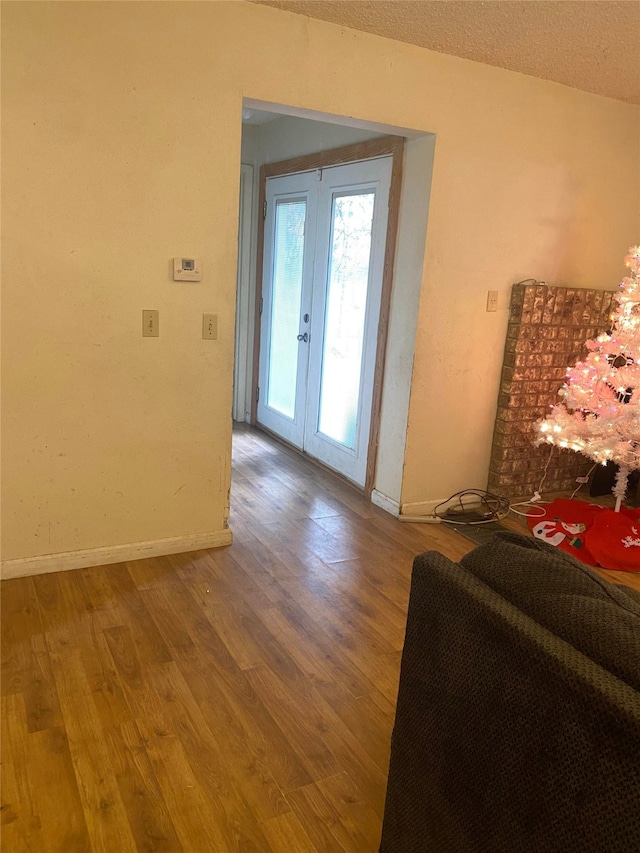 foyer featuring french doors, hardwood / wood-style flooring, and a textured ceiling