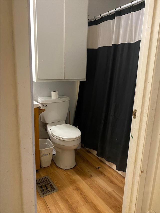 bathroom featuring toilet, vanity, and hardwood / wood-style flooring