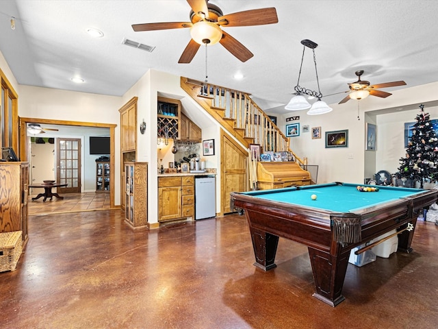 game room with bar area, a textured ceiling, and pool table