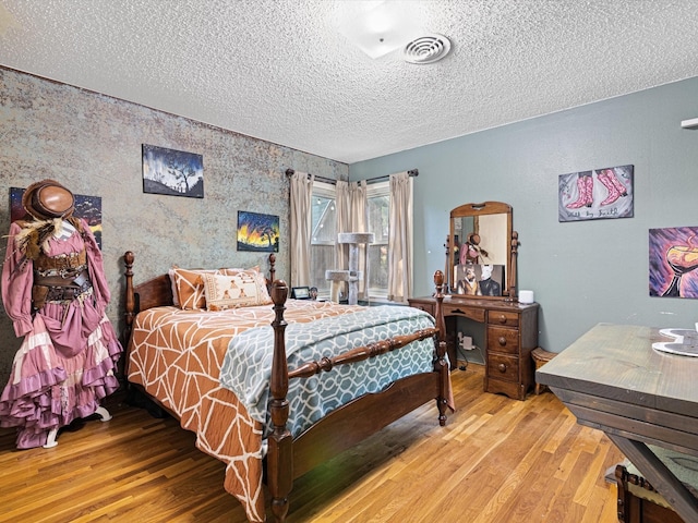 bedroom featuring a textured ceiling and hardwood / wood-style flooring