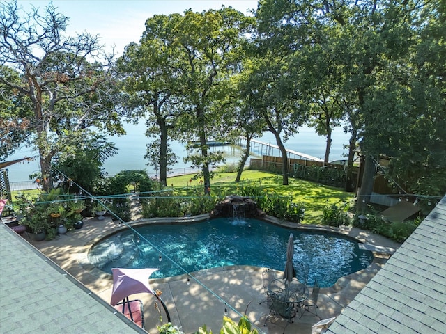 view of pool with a lawn, a patio area, a water view, and pool water feature