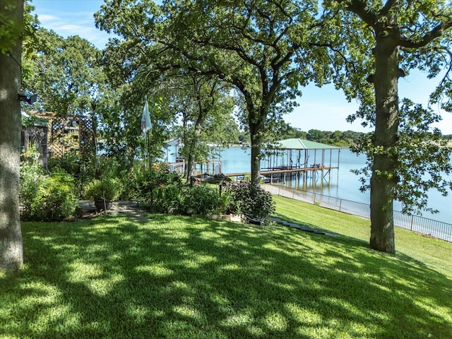 view of yard featuring a water view and a boat dock