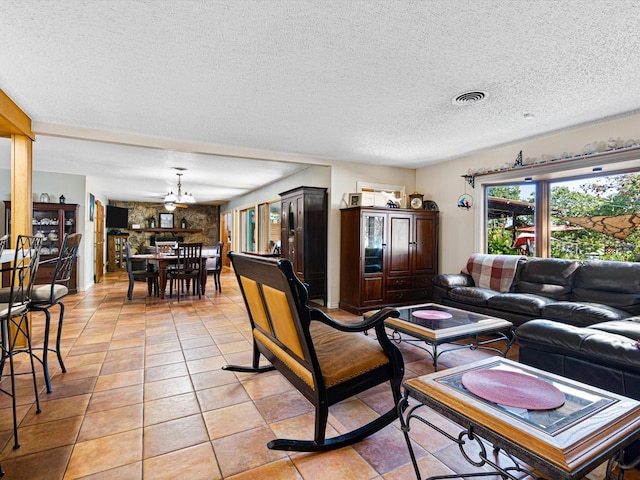 living room featuring ceiling fan, light tile patterned floors, and a textured ceiling