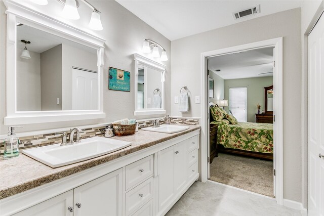 bathroom featuring double sink vanity, tile patterned floors, and decorative backsplash