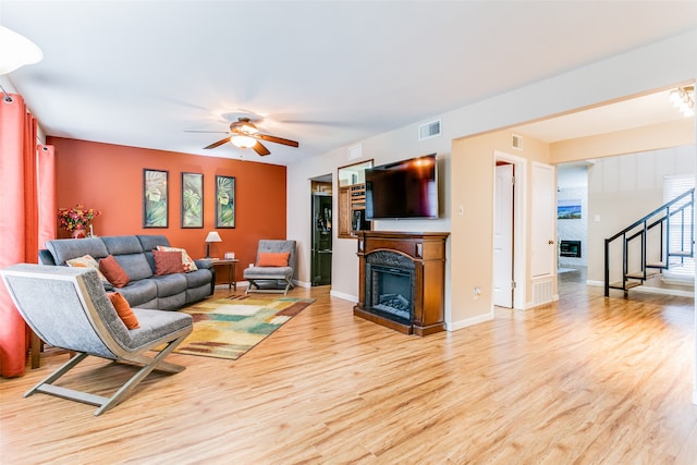 living room featuring ceiling fan and light wood-type flooring