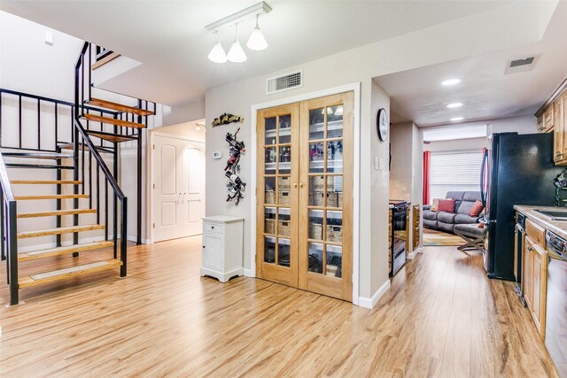 basement with light hardwood / wood-style flooring and french doors