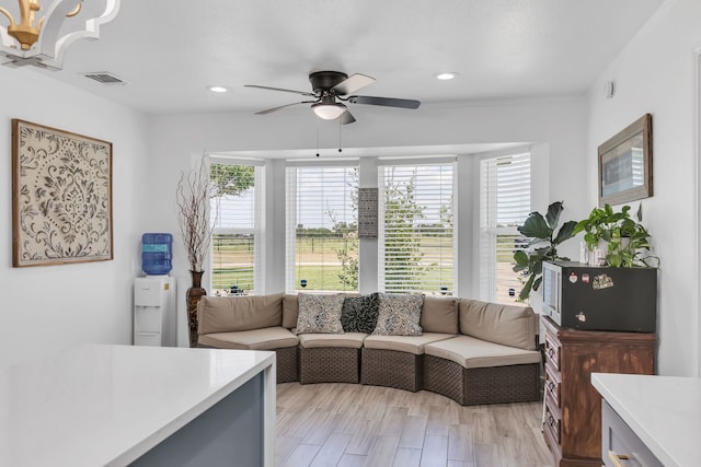 living room featuring light hardwood / wood-style flooring and ceiling fan