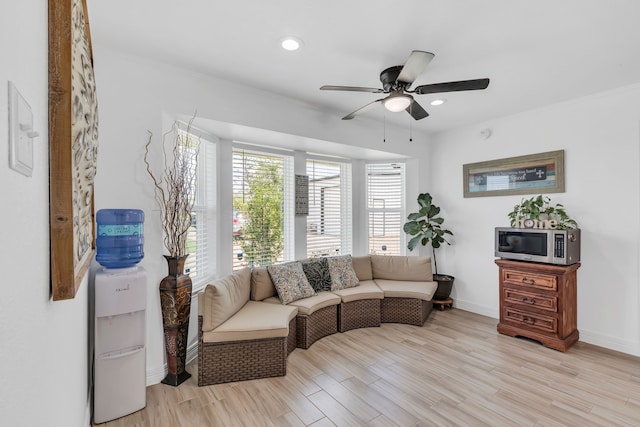 living area with ceiling fan and light hardwood / wood-style floors