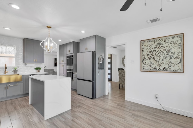 kitchen featuring white refrigerator, sink, a center island, and light wood-type flooring