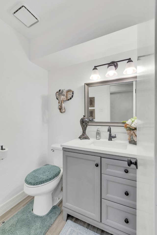 bathroom with wood-type flooring, vanity, and toilet