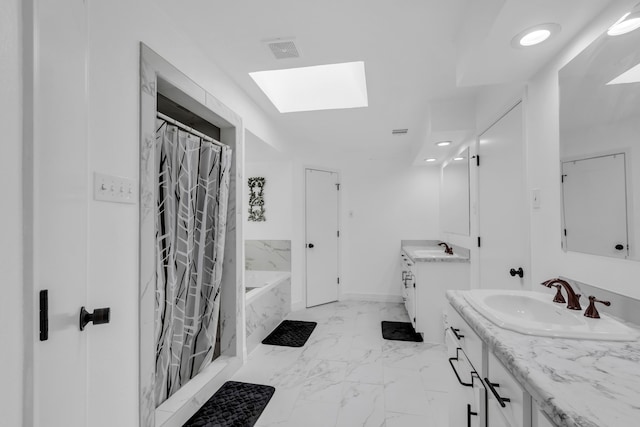 bathroom with a skylight, a bathtub, tile patterned floors, and vanity