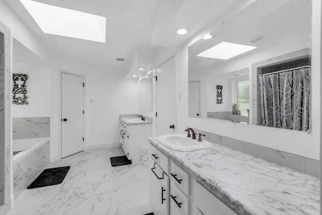 bathroom with a skylight, a tub, tile patterned floors, and vanity