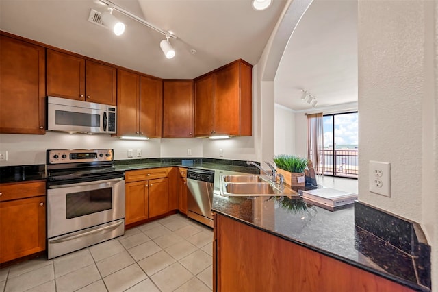 kitchen featuring dishwasher, sink, rail lighting, and range