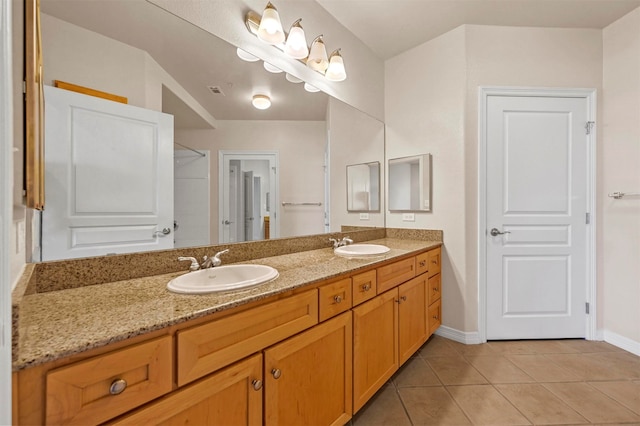 bathroom with dual bowl vanity and tile patterned flooring