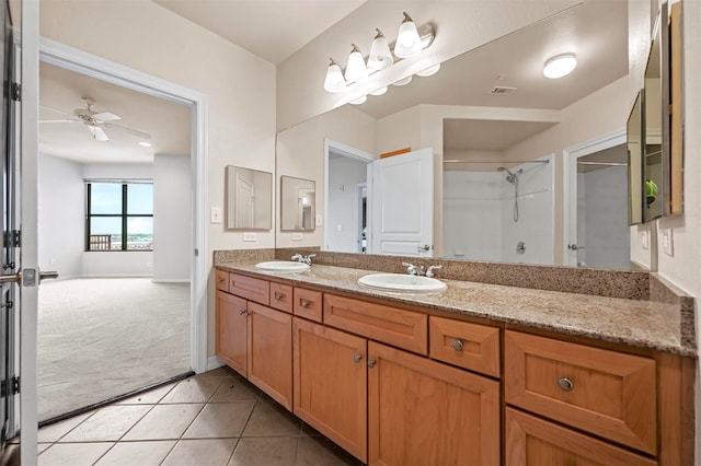 bathroom with ceiling fan, double vanity, walk in shower, and tile patterned floors