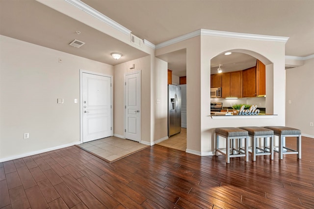 kitchen featuring kitchen peninsula, a kitchen breakfast bar, tile patterned floors, and stainless steel appliances