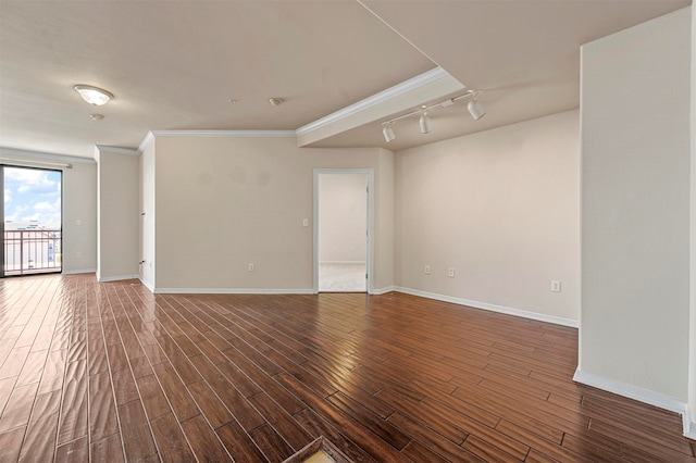 spare room featuring wood-type flooring, ornamental molding, and rail lighting