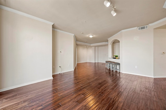 empty room with crown molding, dark hardwood / wood-style flooring, and track lighting