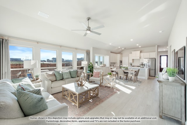 living room with ceiling fan, vaulted ceiling, and light hardwood / wood-style floors