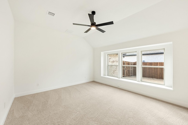 carpeted empty room featuring ceiling fan and vaulted ceiling