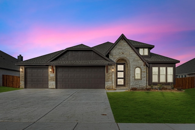 view of front of house featuring a garage and a lawn