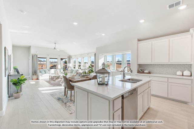 kitchen with a center island with sink, tasteful backsplash, dishwasher, ceiling fan, and sink