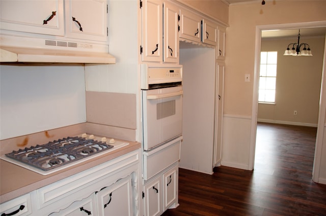 kitchen featuring oven, dark hardwood / wood-style flooring, stainless steel gas stovetop, a notable chandelier, and white cabinets