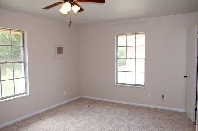 carpeted spare room with a wealth of natural light and ceiling fan