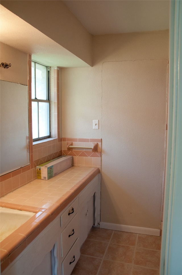 bathroom with tile patterned floors, decorative backsplash, and vanity