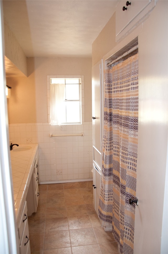 bathroom featuring vanity and tile walls