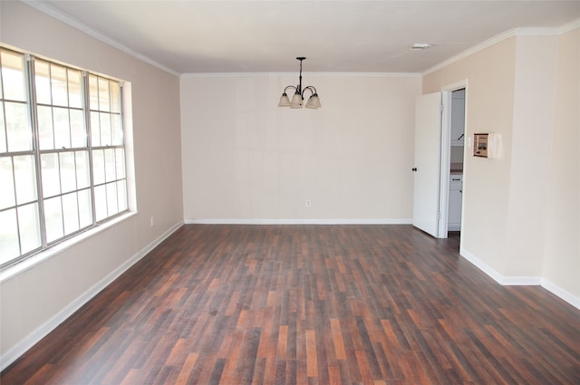 empty room featuring crown molding, dark hardwood / wood-style flooring, and an inviting chandelier