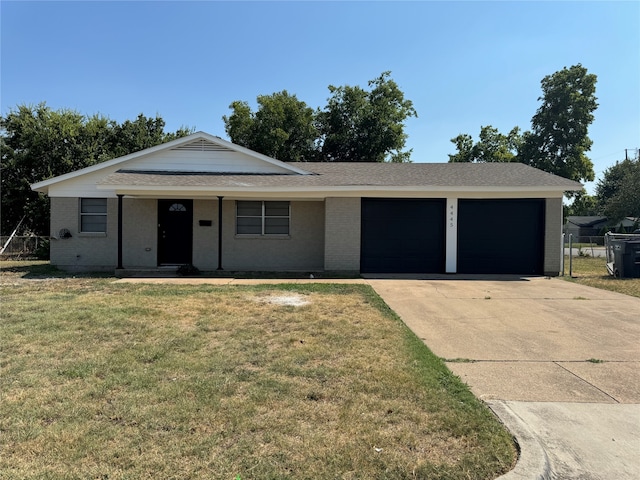 ranch-style home with a garage and a front lawn