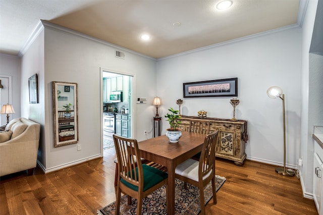 dining room with ornamental molding and dark hardwood / wood-style floors