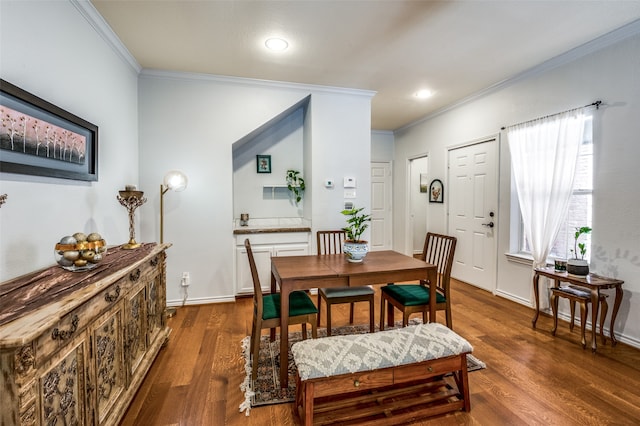 dining space with ornamental molding and dark hardwood / wood-style floors