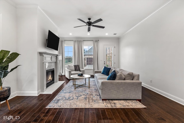 living room featuring a fireplace, crown molding, ceiling fan, and dark wood-type flooring