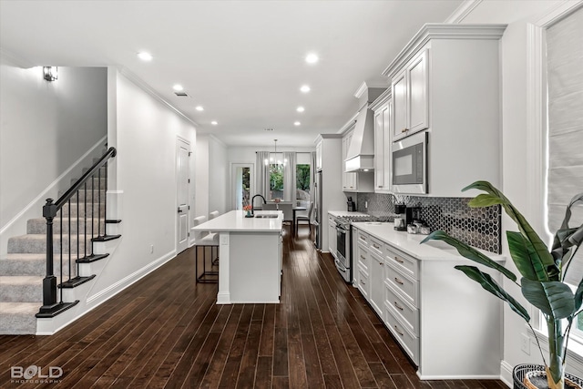 kitchen featuring a kitchen bar, backsplash, a kitchen island with sink, dark hardwood / wood-style flooring, and stainless steel appliances