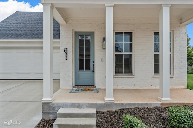 doorway to property featuring covered porch and a garage