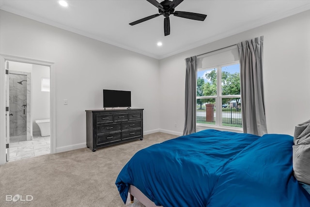 carpeted bedroom featuring ceiling fan, crown molding, and ensuite bathroom