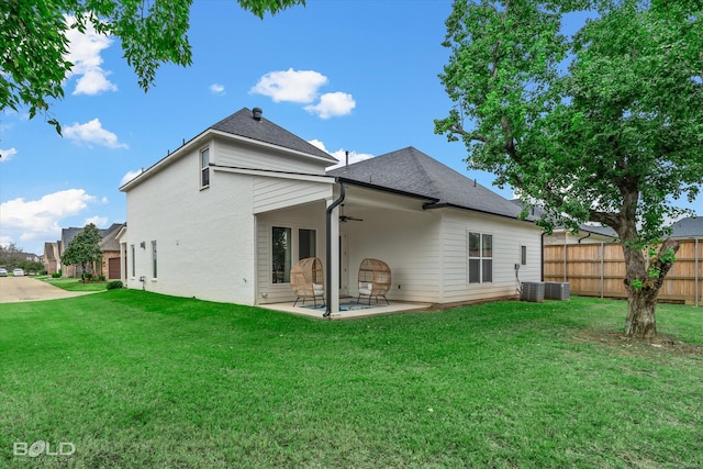 rear view of house featuring ceiling fan, a yard, and a patio