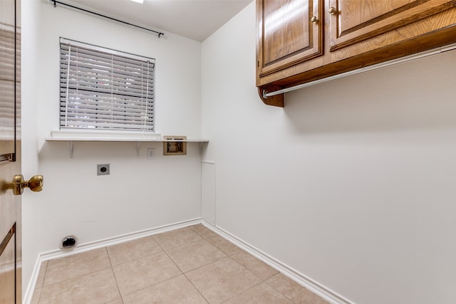 clothes washing area with washer hookup, cabinets, light tile patterned floors, and hookup for an electric dryer